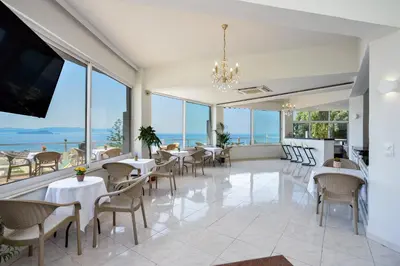 a restaurant with tables and chairs and a view of the ocean at Loucerna Suites Chania in Chania Town