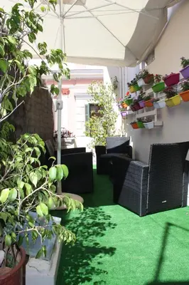 a patio with green carpet and chairs and plants at MmeBassia in Chania Town
