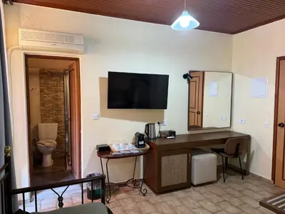 a hotel room with a desk and a television on the wall at Helena Hotel in Chania Town