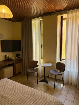 a hotel room with a bed and a table and chairs at Helena Hotel in Chania Town