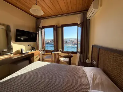 a bedroom with a bed and a desk with a view at Helena Hotel in Chania Town