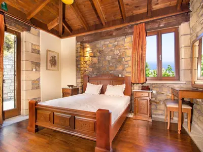 a bedroom with a bed and a stone wall at Falasarna Villas in Falasarna