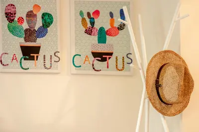 two pictures of cactus on a wall with a hat at Sea Daffodil apartments in Kissamos