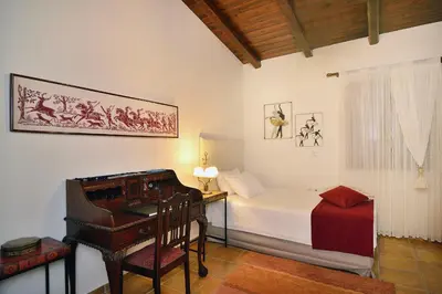 a bedroom with a bed and a desk and a chair at Villa Arhontariki in Kissamos