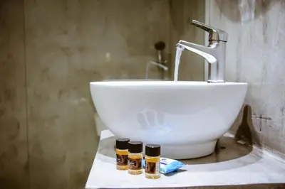 a bathroom sink with three bottles of essential oils on a counter at Gregory Comfort Hotel in Kalamaki Chanion