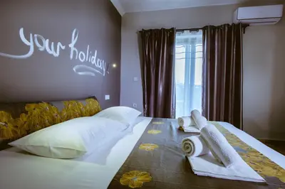 a bedroom with a bed with towels on it at Gregory Comfort Hotel in Kalamaki Chanion