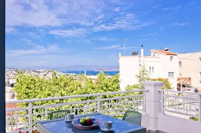 a table on a balcony with a view of the ocean at Barbaras Apartments in Kato Daratso