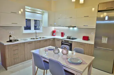 a kitchen with a table and chairs and a refrigerator at Aristea Apartments in Palaiochóra