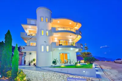 a large white house at night with its lights on at Aristea Apartments in Palaiochóra