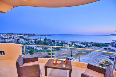 a balcony with a table and chairs and the ocean at Aristea Apartments in Palaiochóra