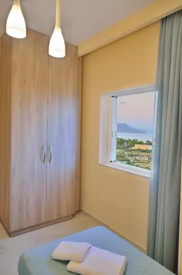 a bedroom with a window and a bed with two towels at Aristea Apartments in Palaiochóra
