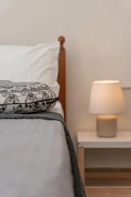 a bedroom with a bed with a lamp on a table at Studio 71!Charming flat in Chania in Chania Town