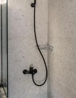 a shower with a black shower head in a bathroom at Studio 71!Charming flat in Chania in Chania Town