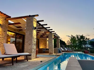 a swimming pool with lounge chairs next to a house at Villa Elena Chania in Karefilianá