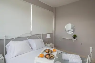 a white bed with a tray of food on a table at Angel-kolymvari4you in Kolymvari