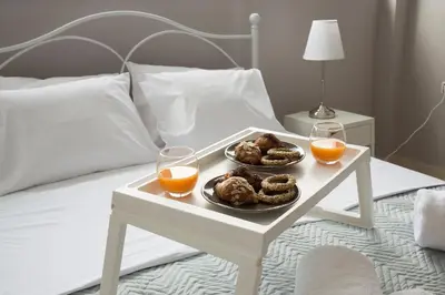 a tray of donuts and two glasses of orange juice on a bed at Angel-kolymvari4you in Kolymvari