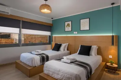 two beds in a room with blue walls at Nidus Villa in Souda