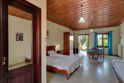 a bedroom with a bed and a dining room at Heliopetra studios, small village close to beaches in Koprána