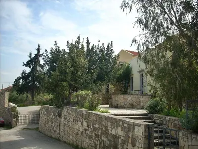a stone retaining wall in front of a house at Heliopetra studios, small village close to beaches in Koprána