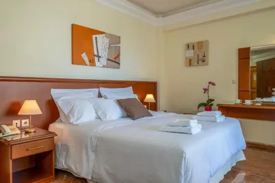 a bedroom with a large white bed with two pillows at Porto Alegre Hotel in Kalamaki Chanion