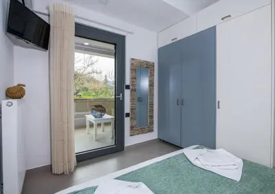 a bedroom with a bed and a sliding glass door at Villa Alyona in Skinés