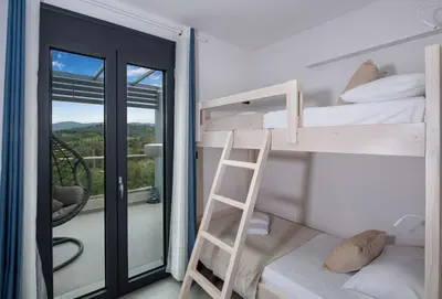 a bunk bed room with a ladder and a balcony at Villa Alyona in Skinés