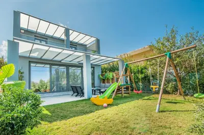 a house with a playground in the yard at Villa Alyona in Skinés