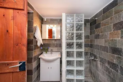 a bathroom with a sink and a glass block wall at Villa Leonton with a private pool in Kissamos