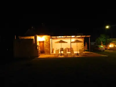 a small building with a table and umbrella at night at Villa Leonton with a private pool in Kissamos