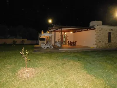 a small house at night with a small tree in the yard at Villa Leonton with a private pool in Kissamos