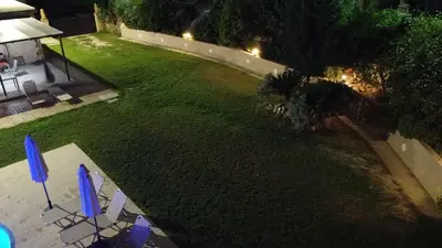 an aerial view of a yard at night with chairs and umbrellas at Villa Leonton with a private pool in Kissamos