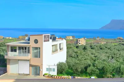 a white house with the ocean in the background at Bee House in Kissamos