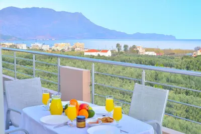 a table with food and orange juice on a balcony at Bee House in Kissamos