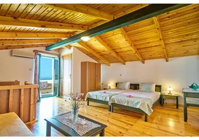 a bedroom with a bed in a room with wooden ceilings at Achilleas Apartments with Sea View in Kolymvari