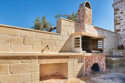 an outdoor pizza oven in a brick wall at Achilleas Apartments with Sea View in Kolymvari