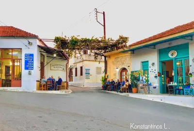 a group of people sitting in chairs on a street at Evaggelias Home Gavalochori in Gavalochori