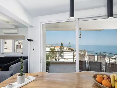 a living room with a table and a view of the ocean at View Point Apartment in Chania Town
