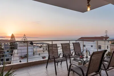 a balcony with chairs and a table with a view of the ocean at View Point Apartment in Chania Town