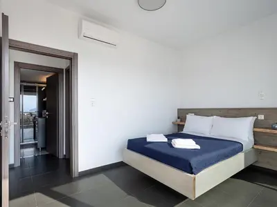 a bedroom with a bed with blue sheets and white pillows at View Point Apartment in Chania Town