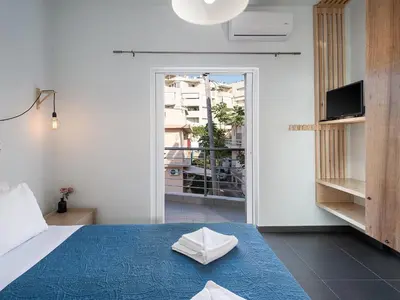 a bedroom with a bed and a sliding glass door at View Point Apartment in Chania Town