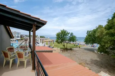 a balcony with a table and chairs and the beach at Seafront Paradise steps to Beach in Plataniás