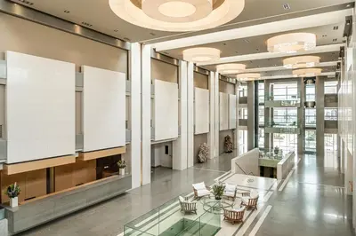 a lobby with tables and chairs in a building at Avra Imperial Hotel in Kolymvari