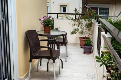 a small table and chairs on a balcony with plants at Dreamy Holidays Apartment in Chania Town