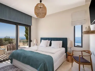 a bedroom with a bed with a view of the ocean at Villa Jamila by Cura Villas Collection in Kalathas