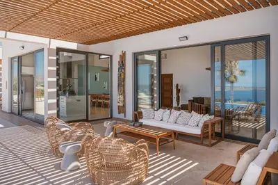 a living room with a couch and chairs on a patio at Villa Jamila by Cura Villas Collection in Kalathas