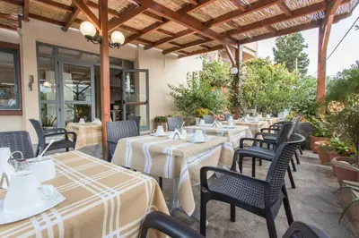 a restaurant patio with tables and chairs and awning at Glaros Hotel in Palaiochóra