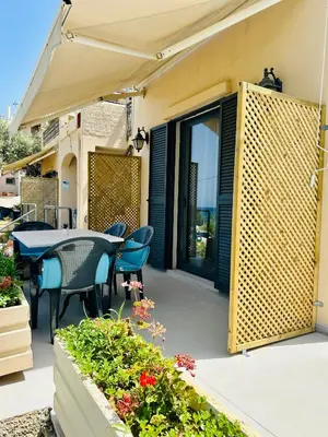 a patio with a table and chairs and an umbrella at Terpsichori villa and apartments in Kalamaki Chanion