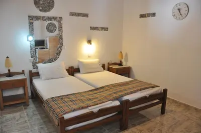 a bedroom with two beds and a clock on the wall at Beach Studio next to the center in Kissamos