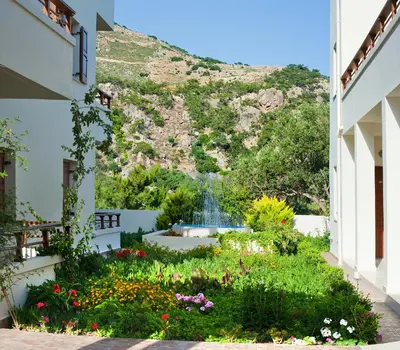 a garden with a waterfall in the background at Syia Hotel in Sougia