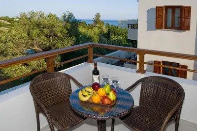 a table with a bowl of fruit and a bottle of wine at Syia Hotel in Sougia